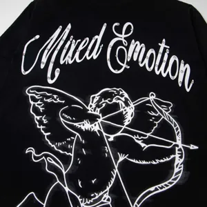 Gros plan détaillé du t-shirt à manches longues noir avec graphique de cupidon et texte strass.