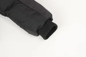 Detailed view of the black padded jacket sleeve featuring ribbed elastic cuffs for warmth.