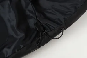 Black padded jacket detail shot showing elastic drawstring, cord lock, and metal grommets.