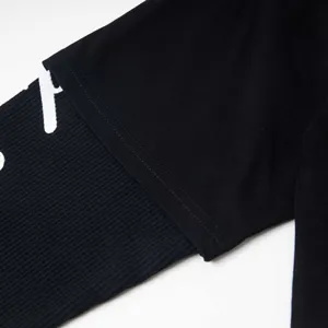Gros plan sur le détail de la manche du t-shirt noir élégant avec une belle impression.