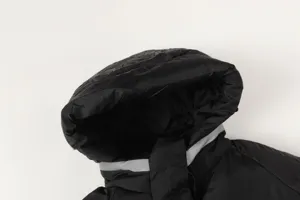 Hood detail of black functional padded jacket with reflective stripe for daily wear.
