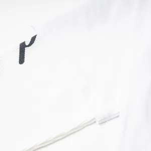 Gros plan détaillé de la manchette d'un t-shirt à manches longues blanc avec motif.