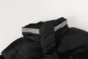 Collar and hood detail of black functional hooded puffer jacket showing reflective strip design.