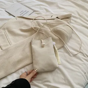 Borsa a tracolla beige minimalista per cellulare con chiusura a perla e nappa per donne.