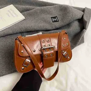 Sac à épaule bandoulière marron en cuir, style moto vintage avec boucles en métal et rivets.