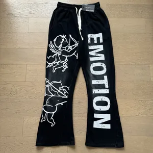 Detailed shot of black casual sweatpants featuring unique cherub graphics and bold letter print.
