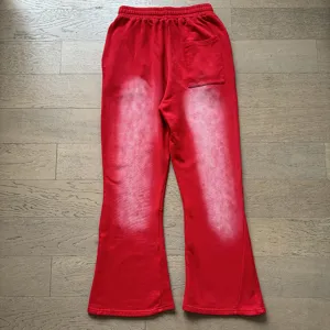 Red flare sweatpants with bleached spray gradient effect, casual streetwear lounge trousers.