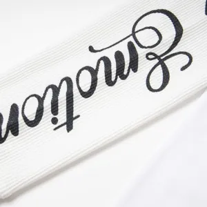 Détail en gros plan d'un tissu côtelé blanc pour t-shirt à manches longues avec texte Emotion.