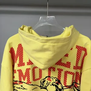 Yellow hooded sweatshirt featuring back red polka dot letter print and artistic graphic design.