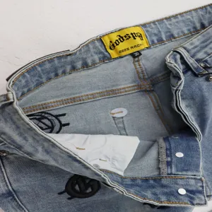 Men's retro light wash denim jeans with stylish embroidery and waistband brand label.