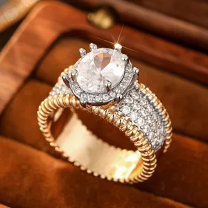 Elegante anillo ancho bicolor de metal con circonita ovalada y pavé brillante para mujer.