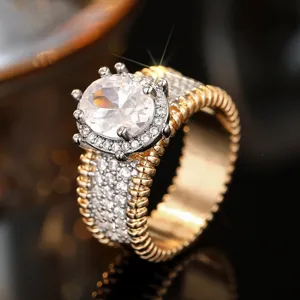 Exquisito detalle de anillo de cristal bicolor con piedra ovalada y borde dorado.