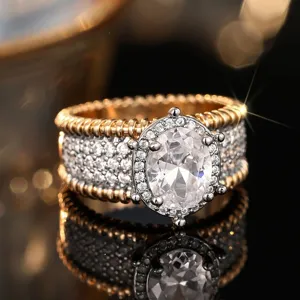 Anillo ancho bicolor con diamantes de pavé, bordes de cuerda y brillante piedra central ovalada.