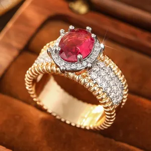 Primer plano detallado de un anillo vintage bicolor de gema roja con halo de cristales.