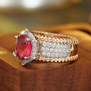 Primer plano detallado de un elegante anillo bicolor con piedra preciosa y circonitas brillantes.