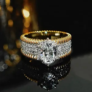 Primer plano detallado de un anillo ancho bicolor de lujo con piedra central brillante.