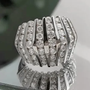 Brede strassring in futuristische stijl met verticale metalen staven, trendy sieraden.