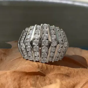 Prachtige brede statement ring met sprankelende strass-steentjes en gladde metalen ribben.