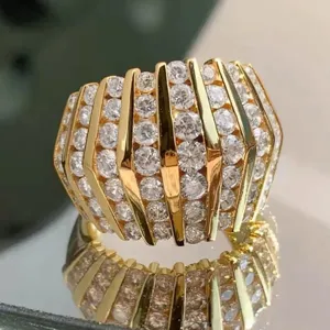 Gedetailleerde close-up van een brede vergulde statement ring met strass, futuristische stijl.