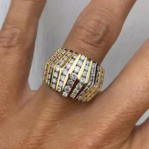 Close-up detail van brede multi-rij pave diamanten statement ring in glanzende gouden look.
