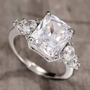 Exquisito anillo plateado con piedra central radiante y circonitas brillantes y elegantes.