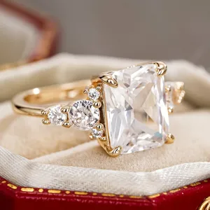 Elegante anillo con circonita talla radiante en color oro con piedras laterales para mujeres.