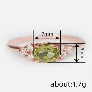 Gros plan détaillé d'une bague minimaliste en or rose avec pierre verte ovale 7x5mm et strass.