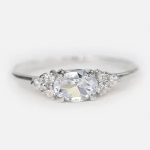 Vue détaillée d'un élégant anneau en argent minimaliste avec pierre centrale ovale et strass.