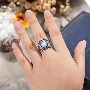 Primer plano detallado del anillo punk vintage de estrella y luna con piedra azul en el dedo.