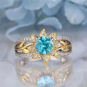 Stunning sunburst blue gemstone ring detailed close-up, elegant floral design with shimmering pavé band.