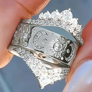 Exquisito juego de anillos 3 en 1 plateados con corona y motivos celestiales de sol, luna y piedras.