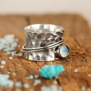Vintage silver spinner ring with hammered texture leaf detail and blue gemstone for women