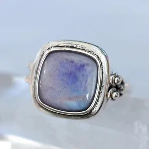 Anillo de plata estilo vintage con una gema cuadrada azul y morada con acabado antiguo.