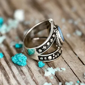 Detalle de anillo de plata estrella luna estilo punk vintage, fotografía macro de piedra azul.