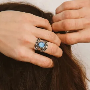 Anillo de plata estilo punk vintage con piedra central azul y detalles de luna y estrella.