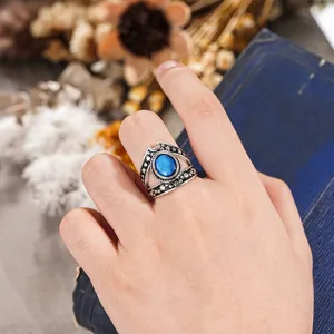 Primer plano de detalle del anillo punk de estrella y luna vintage con piedra azul en mano.