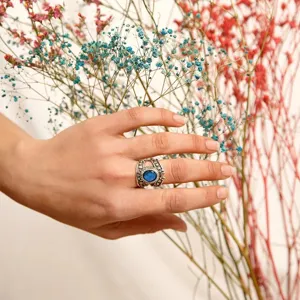 Detalle de anillo vintage de plata con estrella luna y piedra azul, joya de estilo punk único.