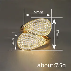 Primo piano dettagliato dell'anello incrociato in zircone dorato con misure precise.