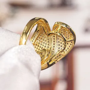 Primo piano dettagliato di un lussuoso anello cuore pavé in oro con pietre scintillanti.