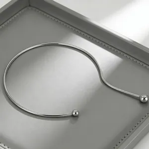 Stainless steel open choker necklace detail, minimalist metal ball collar jewelry.