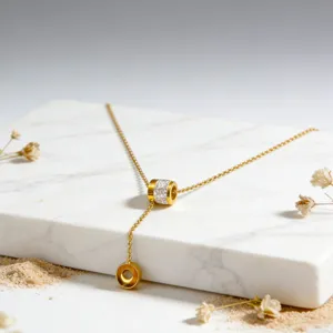 Gedetailleerd close-up van de gouden roestvrijstalen Y-ketting met strass cilinderhanger.