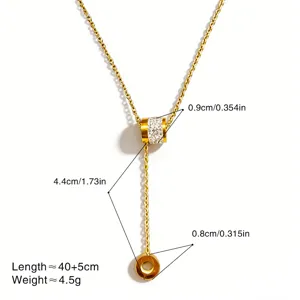 Gedetailleerd uitzicht van de gouden Y-ketting met strass cilinder hanger en fijne ketting.