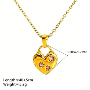 Gros plan détaillé du collier pendentif cœur en or avec des pierres roses scintillantes.