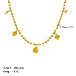 Gold bead ocean necklace detail with seashell and turtle charms, elegant beach jewelry for women.