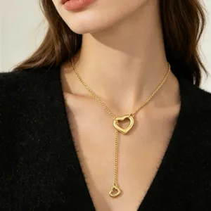 Close-up detail of the gold double heart Y-necklace pendant showing elegant neck wear.