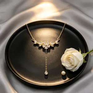 Elegante collar en Y dorado con brillantes de pedrería y diseño de rama de flores.