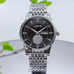 Détail de montre à quartz en acier inoxydable avec cadran sombre strass et bracelet en métal.