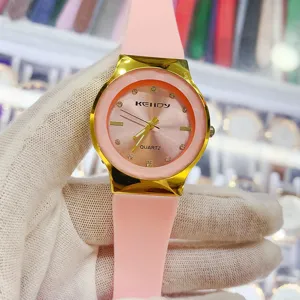 Montre quartz pour femme élégante avec bracelet en silicone rose et boîtier doré chic.