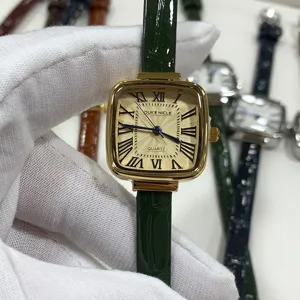 Close-up of the vintage square gold-tone quartz watch with elegant roman numerals and green strap.