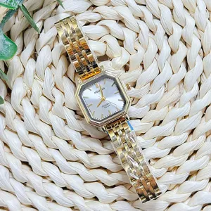 Detail shot of the gold quartz watch with octagonal dial and metallic link strap.